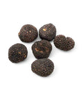 Fresh autumn truffle tuber uncinatum cluster with dark brown to black rough skin